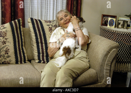 Donna anziana la lettura con il cane nelle vicinanze Foto Stock
