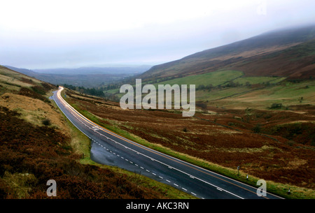 La mattina presto velocità del traffico attraverso il Brecon Beacons avvolgimento strade del paese come la nebbia si deposita sulle colline. Foto Stock