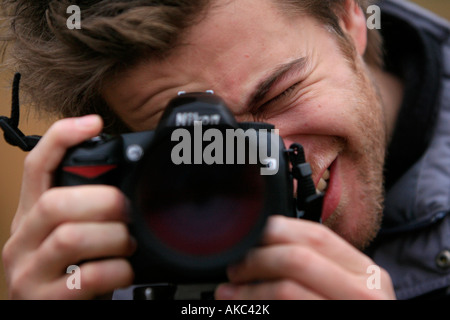 Close-up di un uomo scattare una fotografia con una fotocamera reflex digitale. Foto Stock