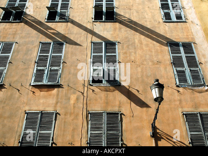 La mattina presto sole proietta ombre sulla facciata di un palazzo nella città vecchia, Nice, Francia Foto Stock