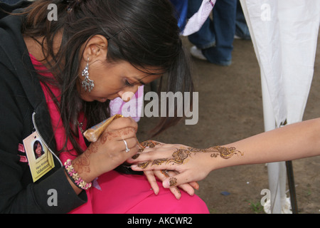 Le ragazze di Henna dipinte sulle loro mani in un festival a un tempio a nord di Londra. Foto Stock