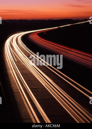 Tramonto al di là del veicolo sentieri di luce tre lane a doppia carreggiata autostrada sulla strada del regno unito al crepuscolo capovolto per mostrare la guida sulla guida a sinistra strade eg Francia Foto Stock
