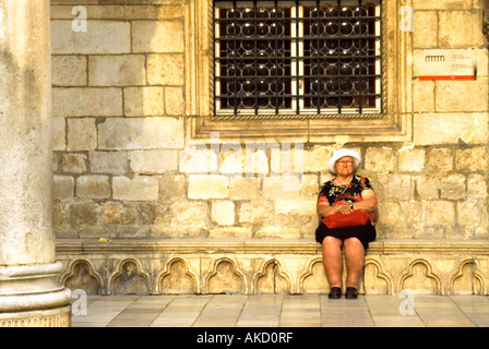 L' Europa sudorientale, Croazia, Dubrovnik, senior donna seduta di fronte a Palazzo del Rettore Foto Stock