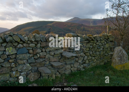 Stile di pietra attraverso il muro di pietra con Latrigg e Skiddaw in background Foto Stock