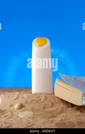 Foto di una bottiglia di protezione solare in plastica bianca senza marchio posta sulla sabbia con un libro cartaceo e conchiglie. Foto Stock