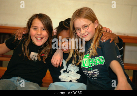 Interracial amici età 12 felicemente abbracciando a livello comunitario il centro giovanile. St Paul Minnesota USA Foto Stock