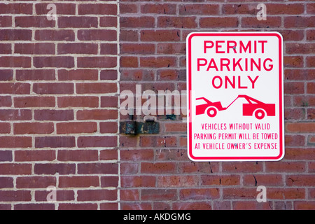 Consentire il parcheggio solo segno sul muro di mattoni - Veicoli senza valido permesso di parcheggio verrà trainato veicolo a spese del proprietario Foto Stock