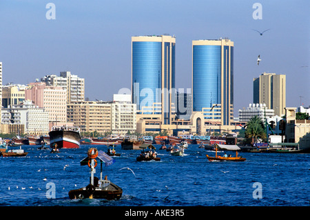 I UAE Dubai, Dhau's und Abra's am Dubai-Creek Vor den Türmen der Twin Towers im Stadtteil Deira. Foto Stock