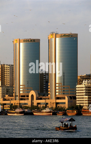 I UAE Dubai, Dhau's und Abra (Wassertaxi) am Dubai-Creek Vor den Türmen der Twin Towers im Stadtteil Deira. Foto Stock