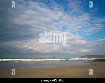 Godrevy point con bianco faro da Gwithian Towans attraverso St Ives Bay con onde che si infrangono sulla vasta spiaggia di sabbia della Cornovaglia Foto Stock