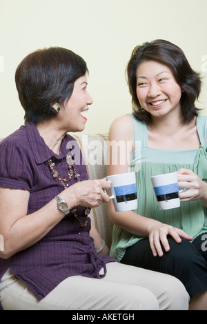 Senior donna e suo nipote poggiarvi bicchieri e sorridente Foto Stock