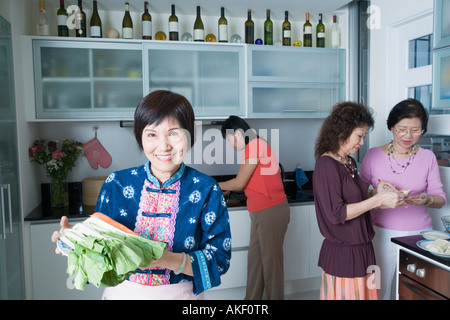 Tre le donne anziane e una donna matura la preparazione di cibi in una cucina domestica Foto Stock