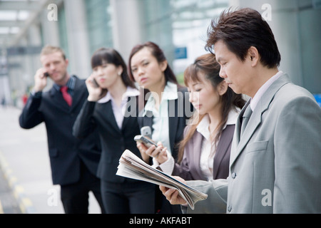 I dirigenti aziendali salutando un taxi in un aeroporto Foto Stock