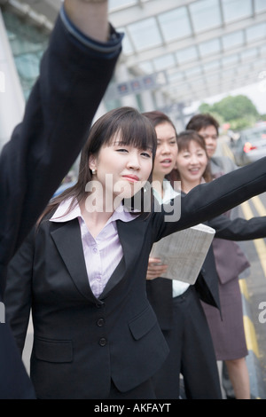 I dirigenti aziendali salutando un taxi in un aeroporto Foto Stock