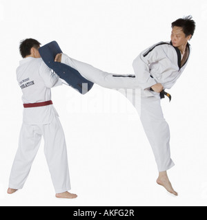 Maschio di istruttore di karate insegnando le arti marziali per un giovane uomo Foto Stock