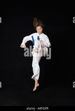 Giovane donna di eseguire Calcio frontale Foto Stock