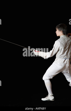 Volante maschio tenendo una lamina di scherma Foto Stock