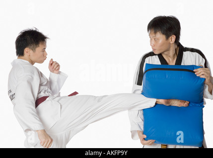 Maschio di istruttore di karate insegnando le arti marziali per un giovane uomo Foto Stock