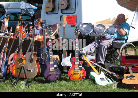 Uomo in sedia a rotelle la vendita di strumenti musicali di Tatton Park Classic Car Show Knutsford Cheshire Foto Stock