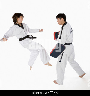 Femmina istruttore di karate insegnando le arti marziali per un giovane uomo Foto Stock