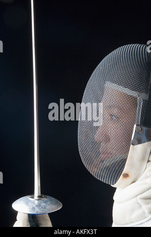 Il profilo laterale di una femmina di fencer tenendo una lamina di scherma Foto Stock