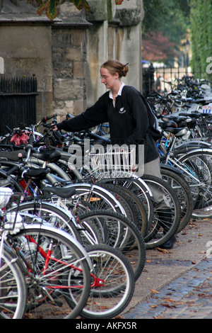 Uno studente lascia la sua bici in una fila di biciclette in rastrelliere in Oxford Foto Stock