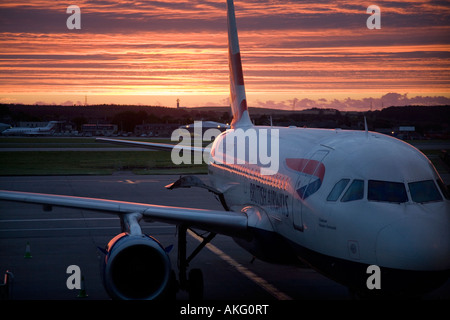 Sunrise oltre British Airways Airbus A319-131 G-EUPM Chatham Historic Dockyard (21451) aereo all'Aeroporto di Aberdeen, Scozia, Regno Unito Foto Stock