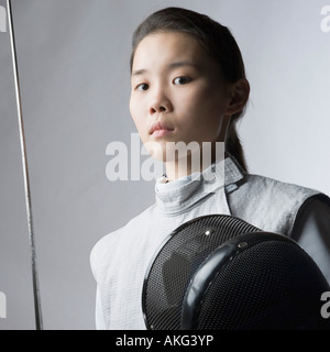 Ritratto di una donna fencer tenendo una spada e una maschera da scherma Foto Stock