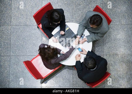 Angolo di alta vista di due imprenditrici con due imprenditori in una sala conferenze Foto Stock