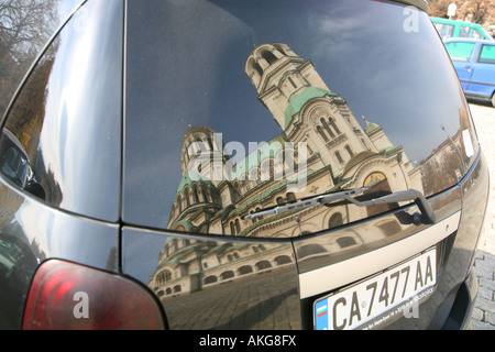 Aleksander Nevski Memorial Church a Sofia in Bulgaria si riflette nel finestrino posteriore di una macchina parcheggiata proprio di fronte a esso Foto Stock