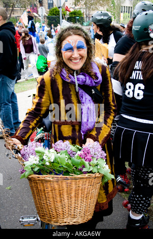 Felice MayDay in costume donna con viola lillà in bicicletta cesto in vimini. MayDay Parade e Festival. Minneapolis Minnesota USA Foto Stock