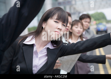 I dirigenti aziendali salutando un taxi in un aeroporto Foto Stock