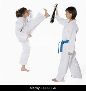 Profilo laterale di due giovani donne a praticare il karate Foto Stock