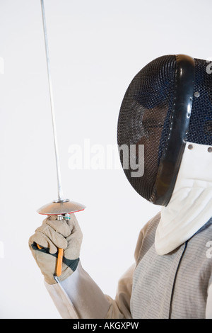 Close-up di una persona che indossa una maschera da scherma e tenendo una lamina di scherma Foto Stock