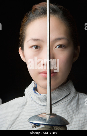 Ritratto di una donna fencer tenendo una lamina di scherma Foto Stock