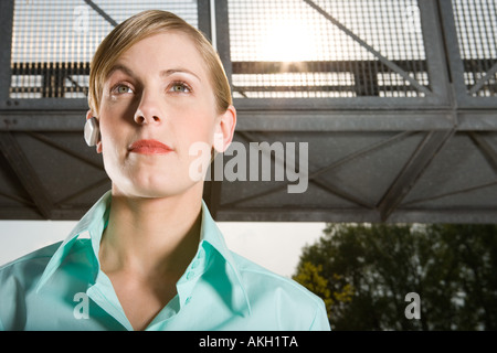 Donna che indossa la cuffia all'aperto permanente Foto Stock