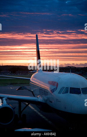 Sunrise oltre British Airways Airbus A319-131 G-EUPM Chatham Historic Dockyard (21451) aereo all'Aeroporto di Aberdeen, Scozia, Regno Unito Foto Stock