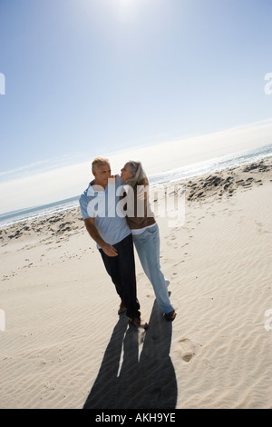 Coppia senior abbracciando sulla spiaggia Foto Stock