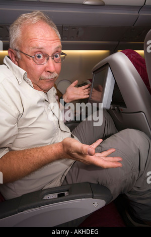 Il viaggio di mezza età passeggeri della compagnia aerea schiacciata in posto in classe economy Foto Stock