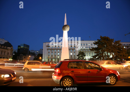 Il traffico di Piazza della Rivoluzione di notte Bucharest Romania Foto Stock