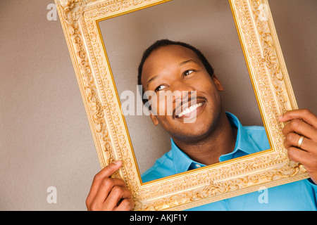 L'uomo africano guardando attraverso la cornice immagine Foto Stock