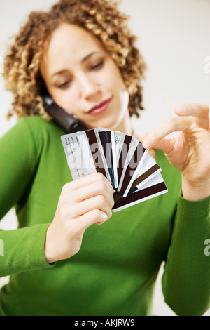 Donna al telefono scegliendo carta di credito Foto Stock