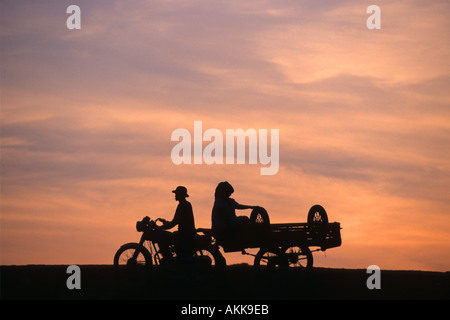 Coppia in motocicletta e roulotte arriva a sunrise per comprare pesci Phnom Krom Siem Reap il Tonle Sap Cambogia Foto Stock