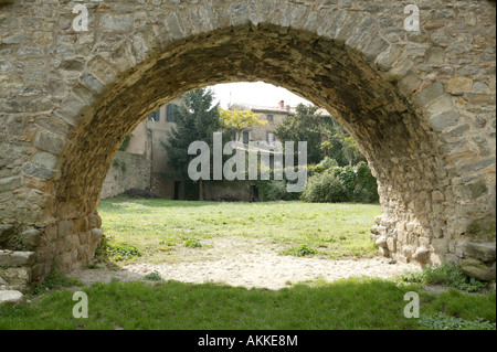 Un ponte storico arco di costruzione tradizionale su un precedente fossato ora coperto da erba Foto Stock