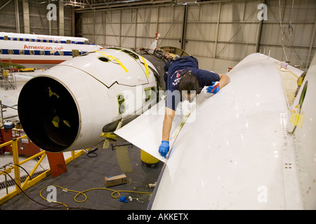 I lavoratori di manutenzione pesante su American Eagle jet Embraer aeroplani a Sawyer International Airport Foto Stock