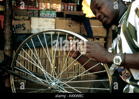 Nero uomo africano facendo noleggio riparazioni presso il suo stallo sul ciglio della strada appena fuori di Beira Mozambico Foto Stock