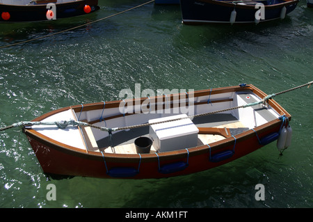 Barca a remi in un chiaro con i paraurti blu mare Porto Coverack Foto Stock