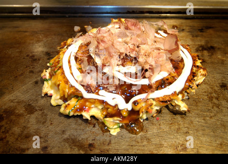 Okonomi yaki stile giapponese gustosi pancake cotti su una piastra calda Giappone Foto Stock