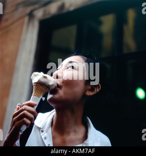 Giovane donna di mangiare un gelato italiano al di fuori del cono Giolotti gelato (icecream) Salottino e pasticceria cafè a Roma Italia EU KATHY DEWITT Foto Stock