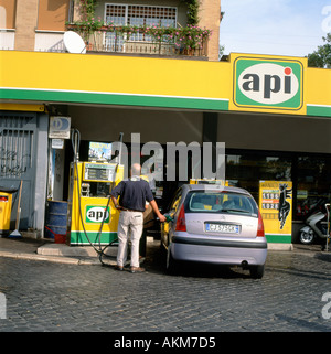 Un uomo di riempire la sua auto con carburante ad un api benzina stazione di gas a Roma Italia KATHY DEWITT Foto Stock